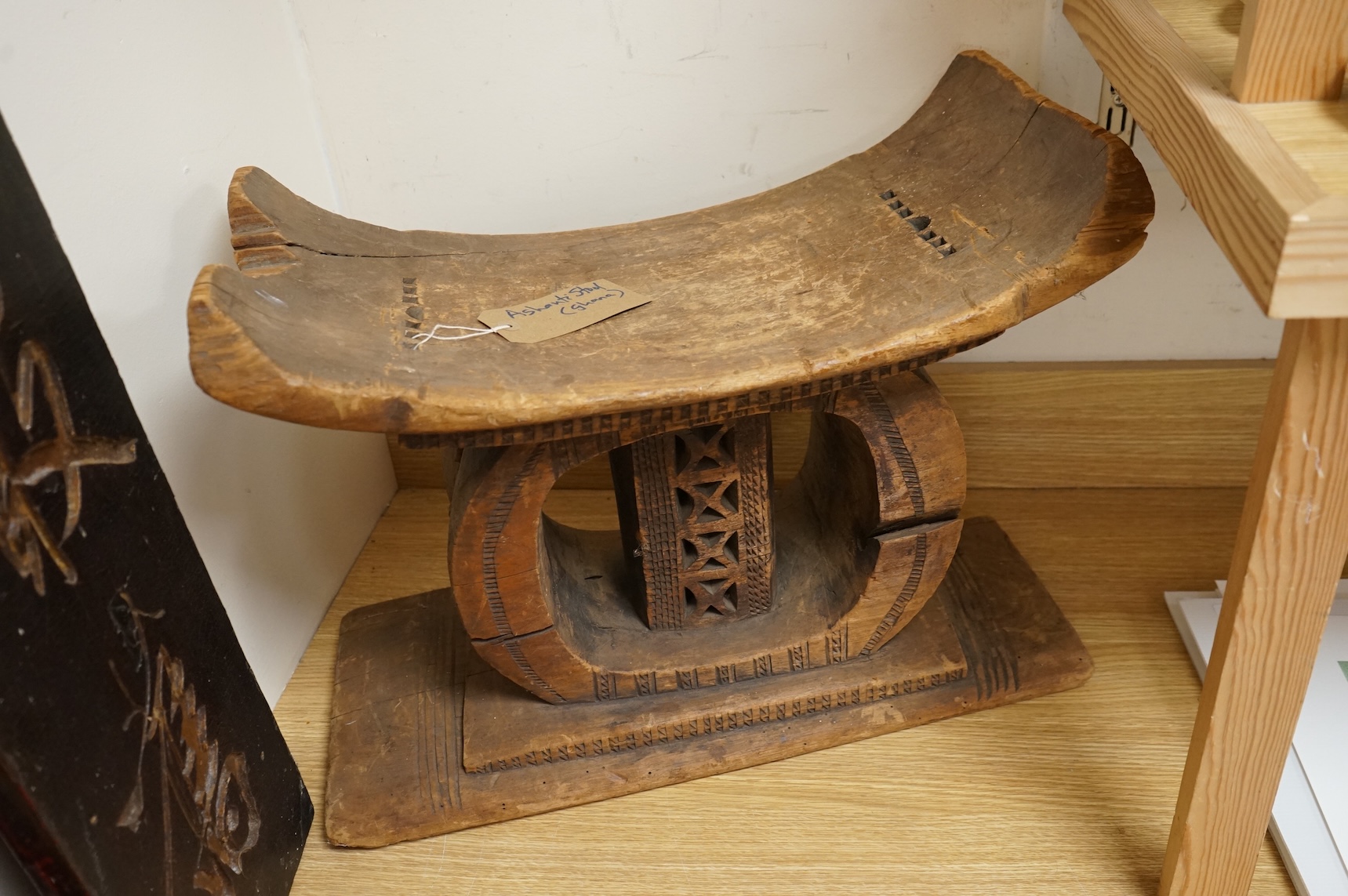 An Ashanti carved wood stool together with a similar headrest, tallest 41cm